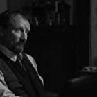 Rainer Bock به عنوان Senior Prosecutor Dr. Reimers