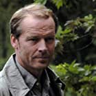 Iain Glen به عنوان Bruce Wayne