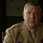 Philip Quast به عنوان Saddam Hussein