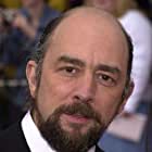 Richard Schiff به عنوان Roland Fancher