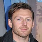 Keir O'Donnell به عنوان Larry Adams