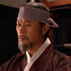 Roe-ha Kim به عنوان Detective Cho Yong-koo