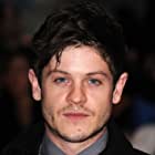 Iwan Rheon به عنوان Mick Mars